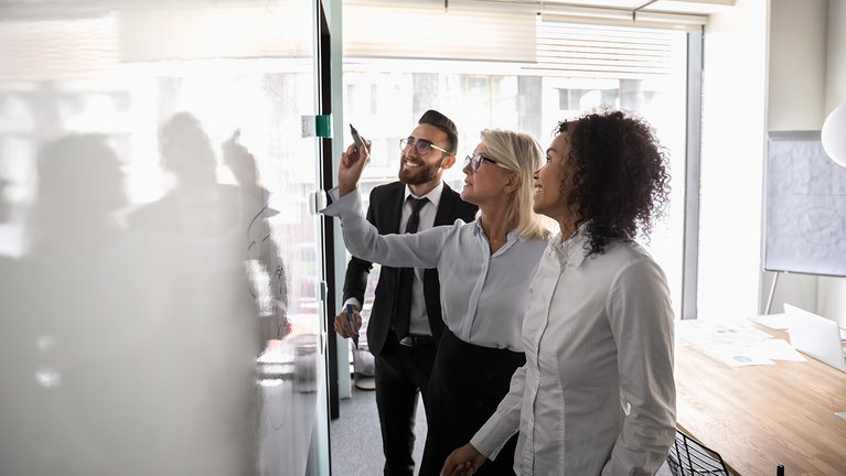 Group of professionals working in front of a whiteboard