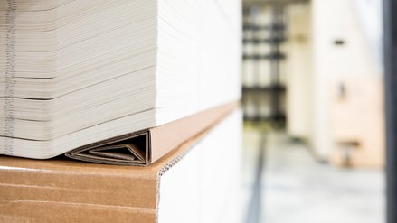 A stack of paper placed on its side on a wedge of cardboard for stability