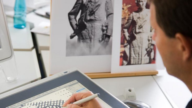 A man finishes sketches on a digital drawing board