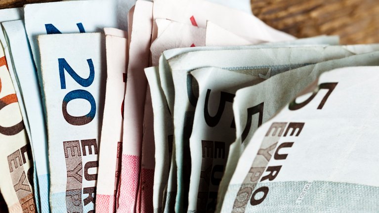 A bundle of euro banknotes, partly somewhat crumpled