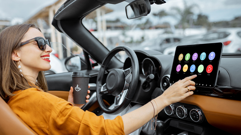 Woman operates the cockpit of her convertible via touchscreen