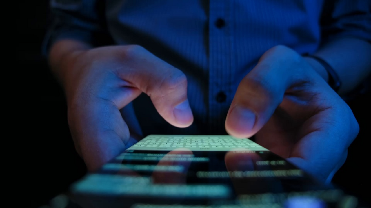 Close-up of a smartphone into which a text is entered with two thumbs