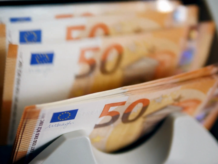 A money counting machine checks, counts, and sorts several 50-euro banknotes