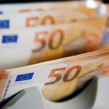 A money counting machine checks, counts, and sorts several 50-euro banknotes