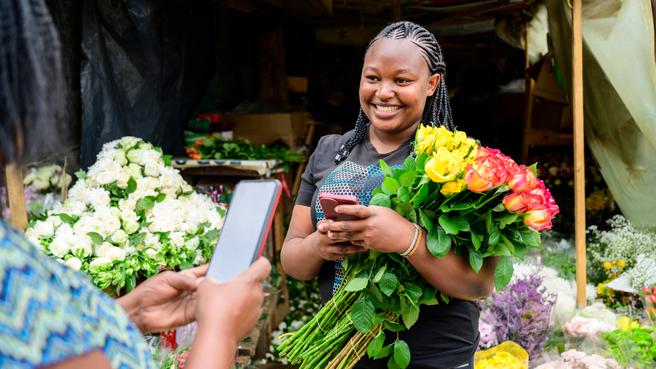 Two women using their smartphones at a market